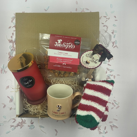 Candy Cane Christmas treat box with peppermint candle, festive mug, cozy socks, popcorn, and hot chocolate