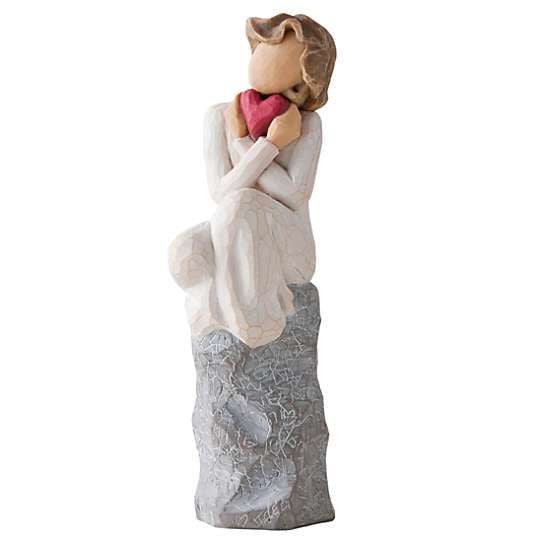 Girl sitting on rock holding a heart