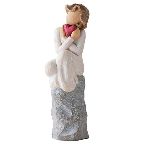 Girl sitting on rock holding a heart