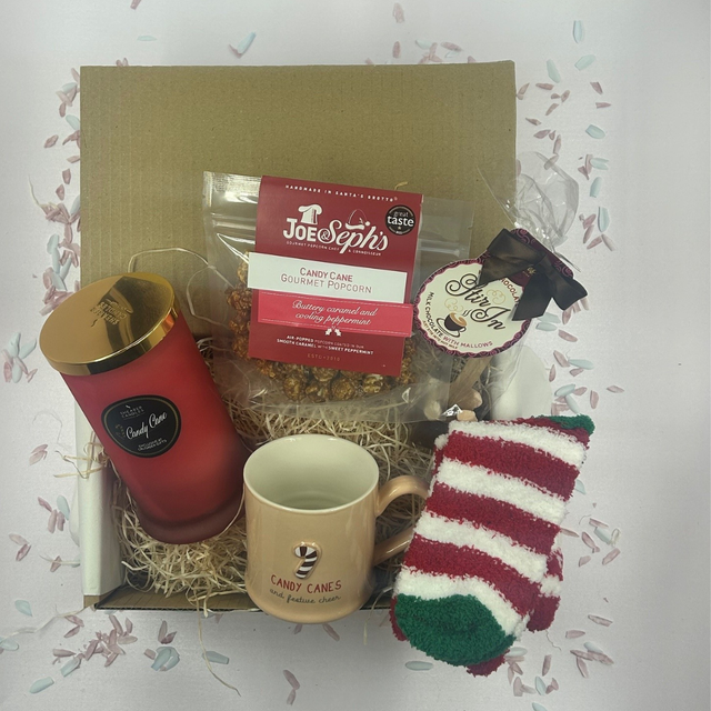 Candy Cane Christmas treat box with peppermint candle, festive mug, cozy socks, popcorn, and hot chocolate